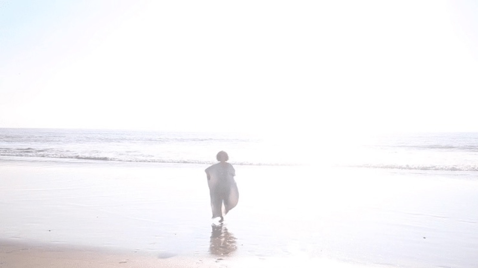 A lone figure at the luminous edge of the sea — a still from At the Edge of the Sea