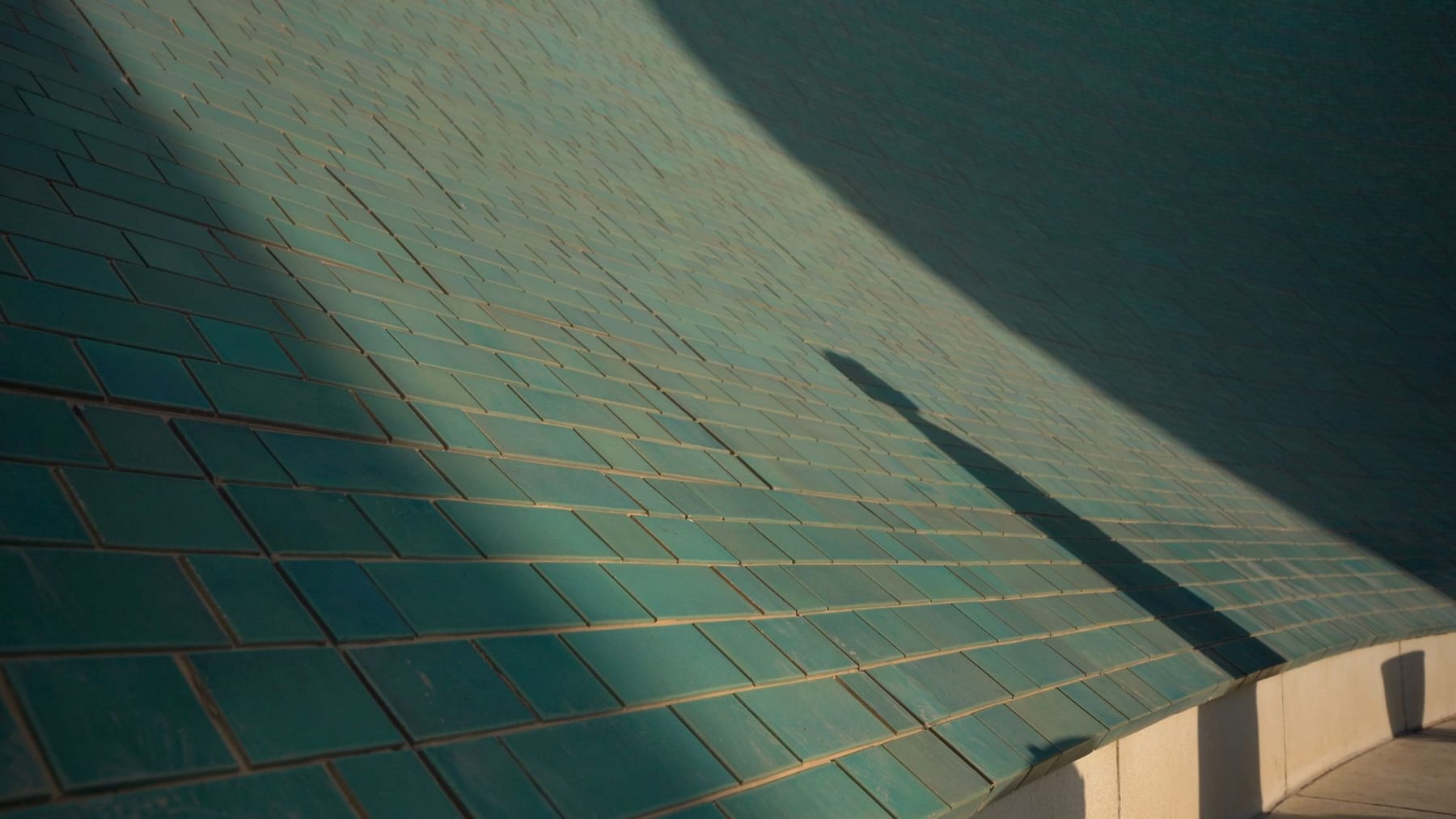 Sunlight crossing the patinated copper tiles of a vast roof — from An Archive of Future Memories