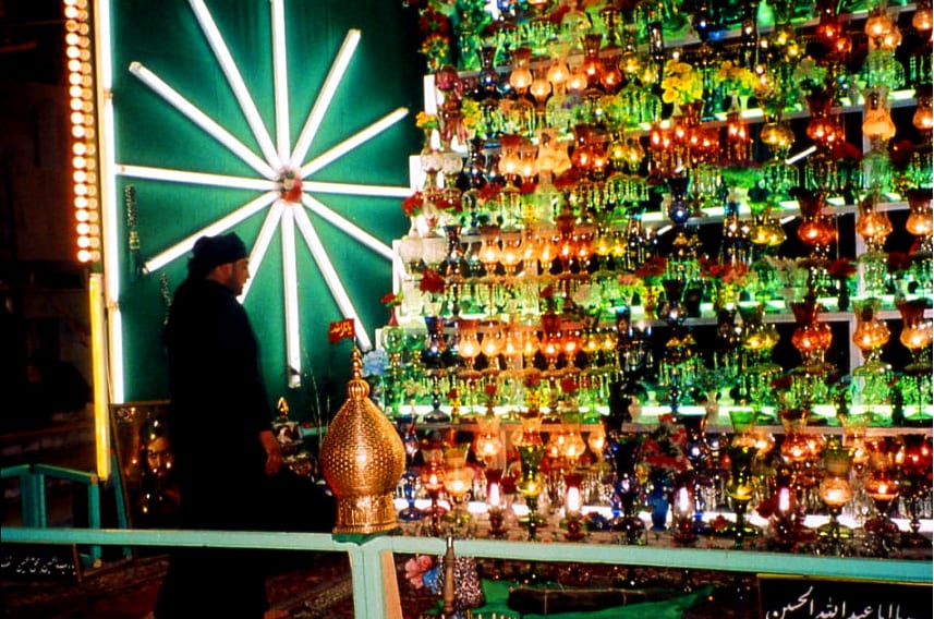An elaborate devotional installation glowing with green, gold, and red light, built by community members for Ashura — Sacred Spaces